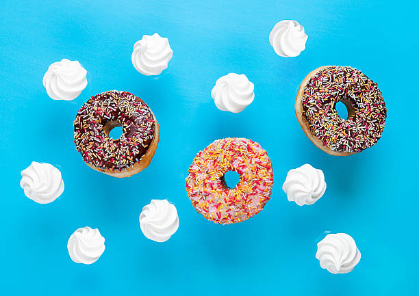 istock Chocolate and pink donuts with meringues on blue 626341248