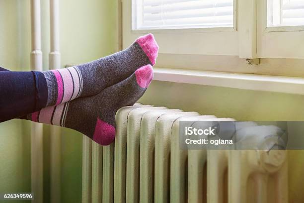 Pies Felices Descansando En El Radiador Blanco Y Cálido Foto de stock y más banco de imágenes de Radiador