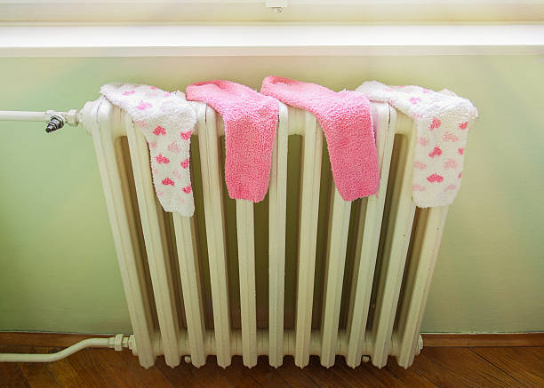 Wet socks drying on a hot radiator stock photo