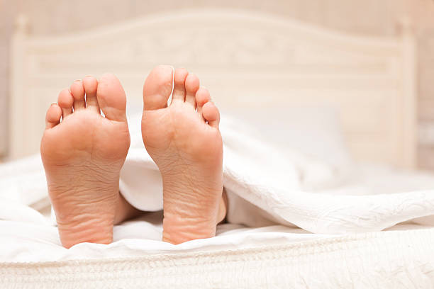 Two feet in a bed focus on feet two feet in a bed focus on feet bed human foot couple two parent family stock pictures, royalty-free photos & images
