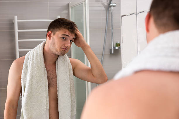 istock Male holding towel on his shoulders while correcting hair 626351748