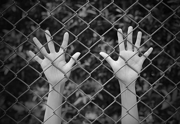 istock Female Hands touching iron mesh, black and white tone 626353032