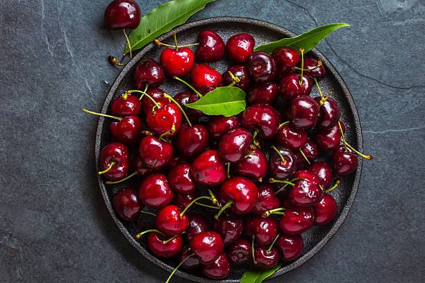 istock Fresh cherry on black plate, slate background. Top view 626354526