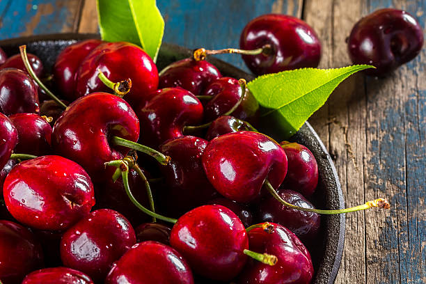 istock Fresh cherry on black plate, wooden background 626354704