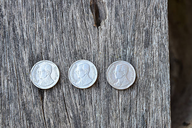 istock Thai coins on wood texture 626361160