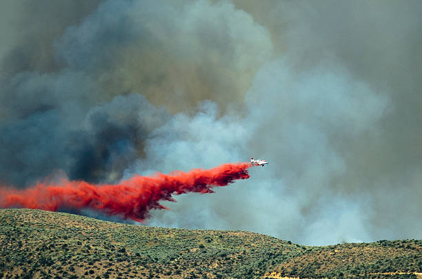 istock White Aircraft Dropping Fire Retardant as it Battles Raging Wildfire 626361632
