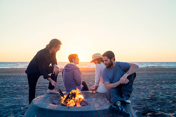 istock Friends hanging out on the beach with a fire 626374034