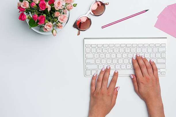 istock Office desk table with female hands, computer, supplies, flowers 626374050