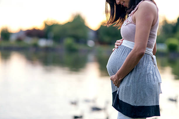 wunderschöne ethnische mutter, um ihren schwangeren bauch zu halten - hispanic male stock-fotos und bilder