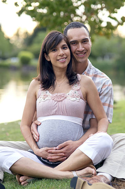 Husband hands on pregnant wife tummy, studio shot isolated on a white background