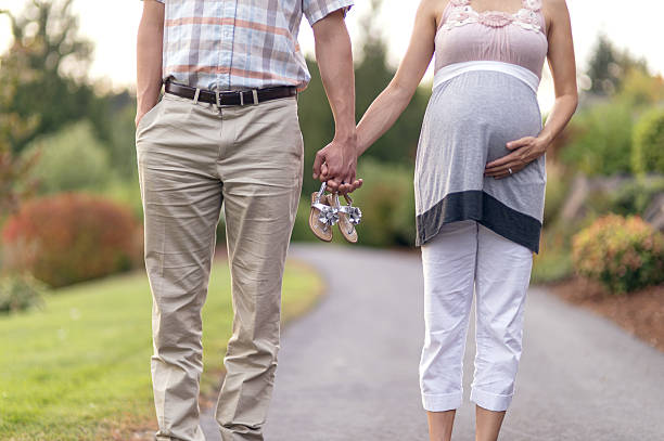 A happy Asian Chinese couple, woman is in nine months pregnant.  Isolated on white background.