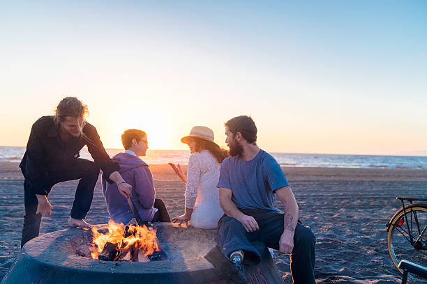 istock Group of friends enjoying a fire on the beach 626374236