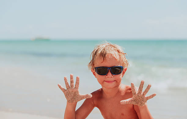 istock little boy having fun on sand beach 626385296