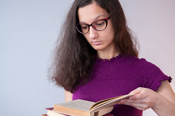 istock The girl in glasses reading interesting book 626386580