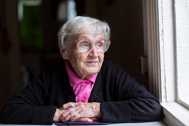 istock An elderly woman sitting near the window. 626387578