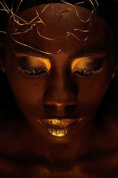 beautiful african woman with creative gold make–up and jewelry stock photo