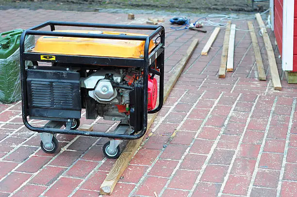 Portable Generator with wheels  on the House Construction Site. Close up on Mobile Backup Generator.