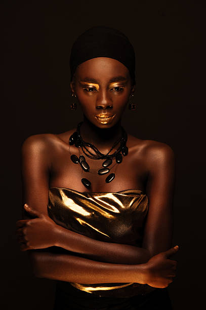 african woman with creative gold make–up and jewelry stock photo