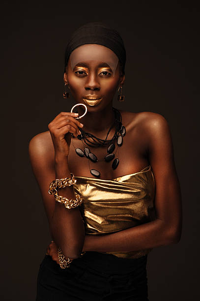 african woman with creative gold make–up and jewelry stock photo
