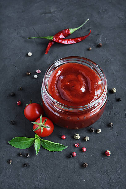 istock Tomato sauce and basil in glass jars 626394402