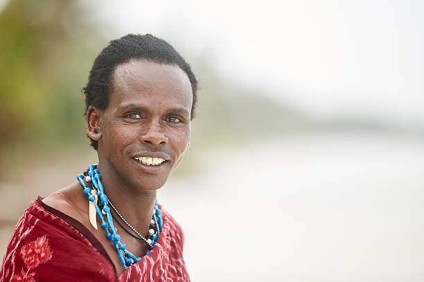 Elegant Maasai man standing under Zanzibar's palm trees.