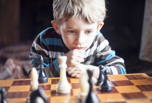 boy (5-10 years old) plays chess
