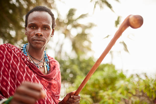 istock Elegant Maasai man standing under Zanzibars palm trees. 626398226