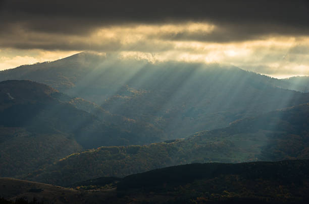 istock Heavy overcast sky with sunrays over meadows and picturesque forests 626399222