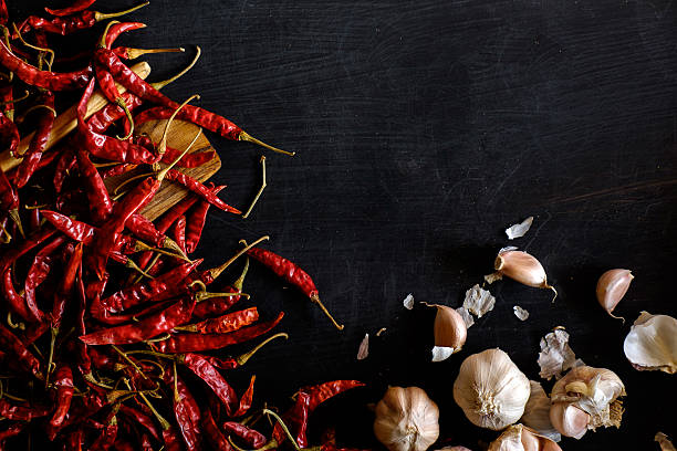istock Garlic cloves and dries chilli on dark wood background. 626399480