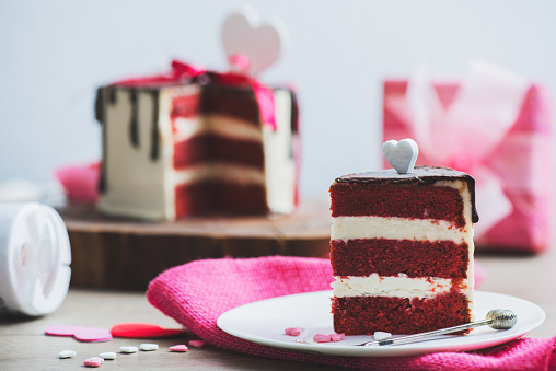 Closeup shot of a piece of a cake with Valentine Day heart shaped decoration around