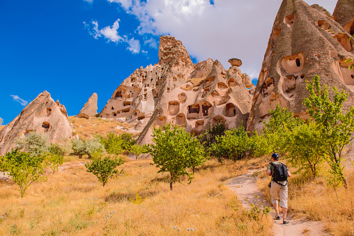 Solo backpacker hiking among the cave rocks in Cappadocia area,  central Turkey