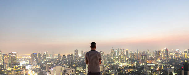uomo sopra il grattacielo superiore - bangkok thailand skyline night foto e immagini stock