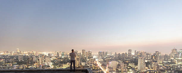 mann über top-hochhaus - raum eine person dunkelheit stehen gegenlicht stock-fotos und bilder