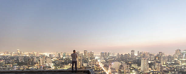 homme au-dessus du gratte-ciel - bangkok thailand skyline night photos et images de collection