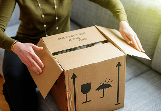 femme déballant un bon colis de boîte en carton surlinse shopping - apartment contemporary action packing photos et images de collection