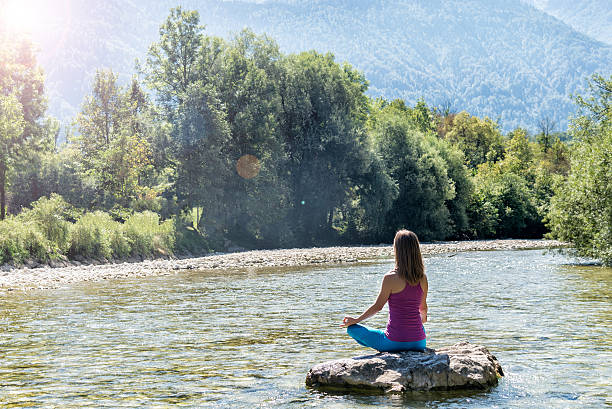 mujer meditando en el río - equanimity fotografías e imágenes de stock