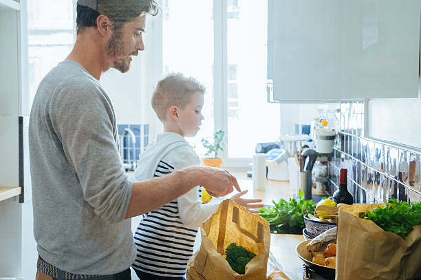 istock Father And Son Organizing Groceries In The Kitchen 626416578