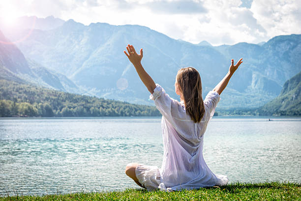 istock Woman meditating at the lake 626421222