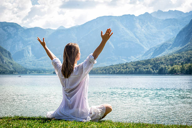 istock Woman meditating at the lake 626421350