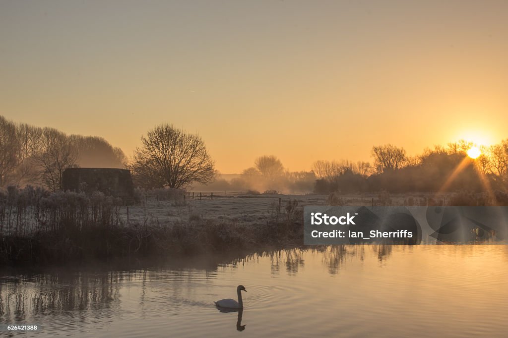 Sunrise Over the River Thames A winter cold frosty Sunrise Over the River Thames at Cheese Wharf, Oxfordshire Winter Stock Photo