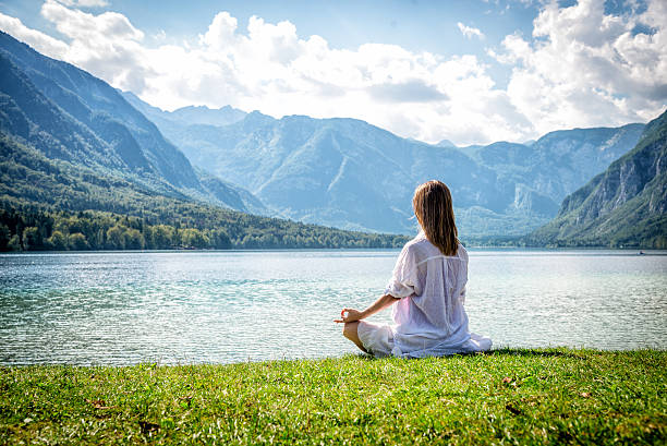 istock Woman meditating at the lake 626421528