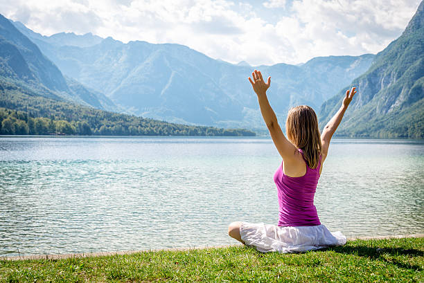 istock Woman meditating at the lake 626421932