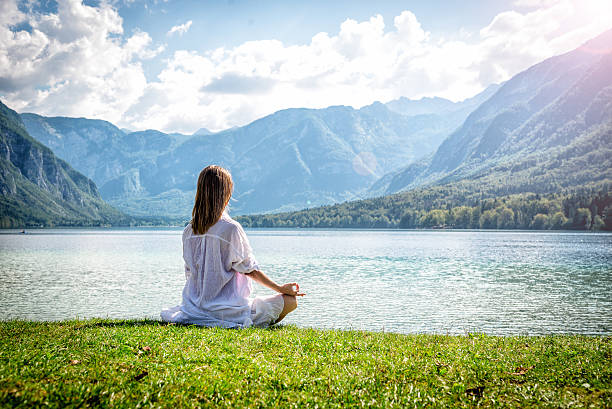 istock Woman meditating at the lake 626422968