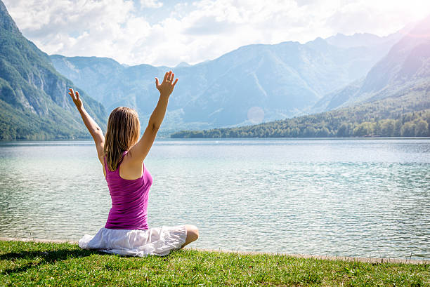 istock Woman meditating at the lake 626423738