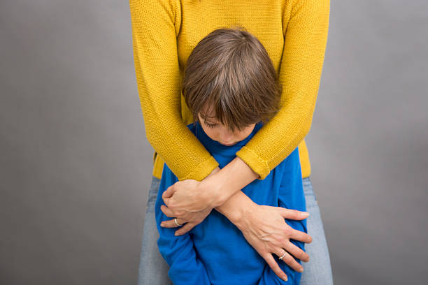 Sad little child, boy, hugging his mother at home, isolated image, copy space. Family concept