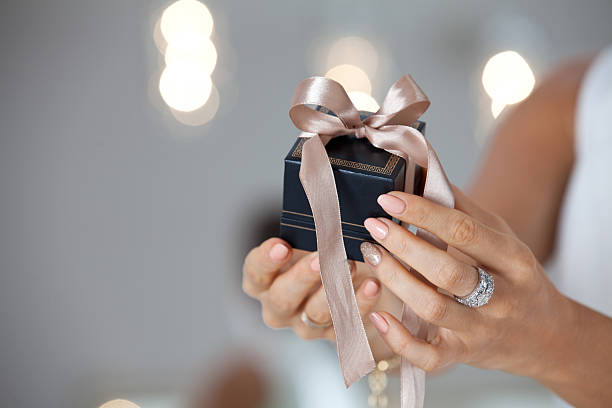 istock Beautiful female hands holding a small gift box. 626424550