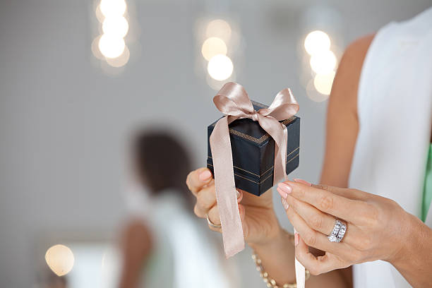 istock Elegant female hands Giving a gift with ribbon. 626426098