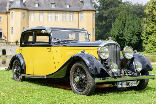 Jüchen, Germany - August 5, 2016: Bentley 3.5 litre Park Ward Sports Saloon 1934 vintage car. Bentley sold only the drivable bare rolling chassis with engine and gearbox, scuttle and radiator, ready for coachbuilders to construct on it. Of the 1177 3Â½ Litre cars that were built, about half of them were bodied by Park Ward The car is on display during the 2016 Classic Days at castle Dyck. The car is displayed in a field.