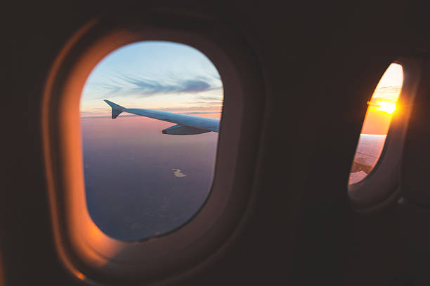 istock Sunset aerial view through airplane window over wings 626427654