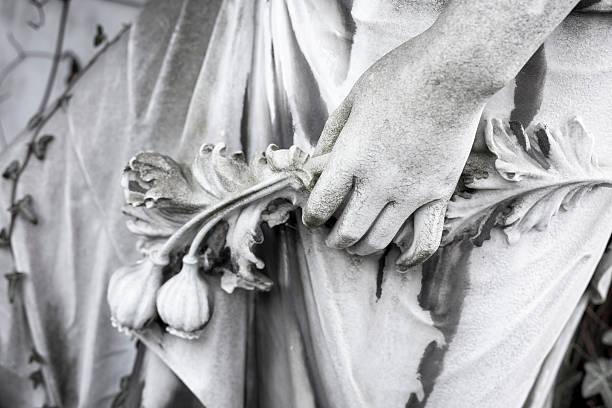 hand with flowers, close up of an old sculpture hand with flowers, close up of an old sculpture. Unknown artist of the 19th century. opium poppy stock pictures, royalty-free photos & images
